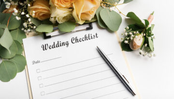 Wedding checklist on a clipboard with pen and floral decorations.